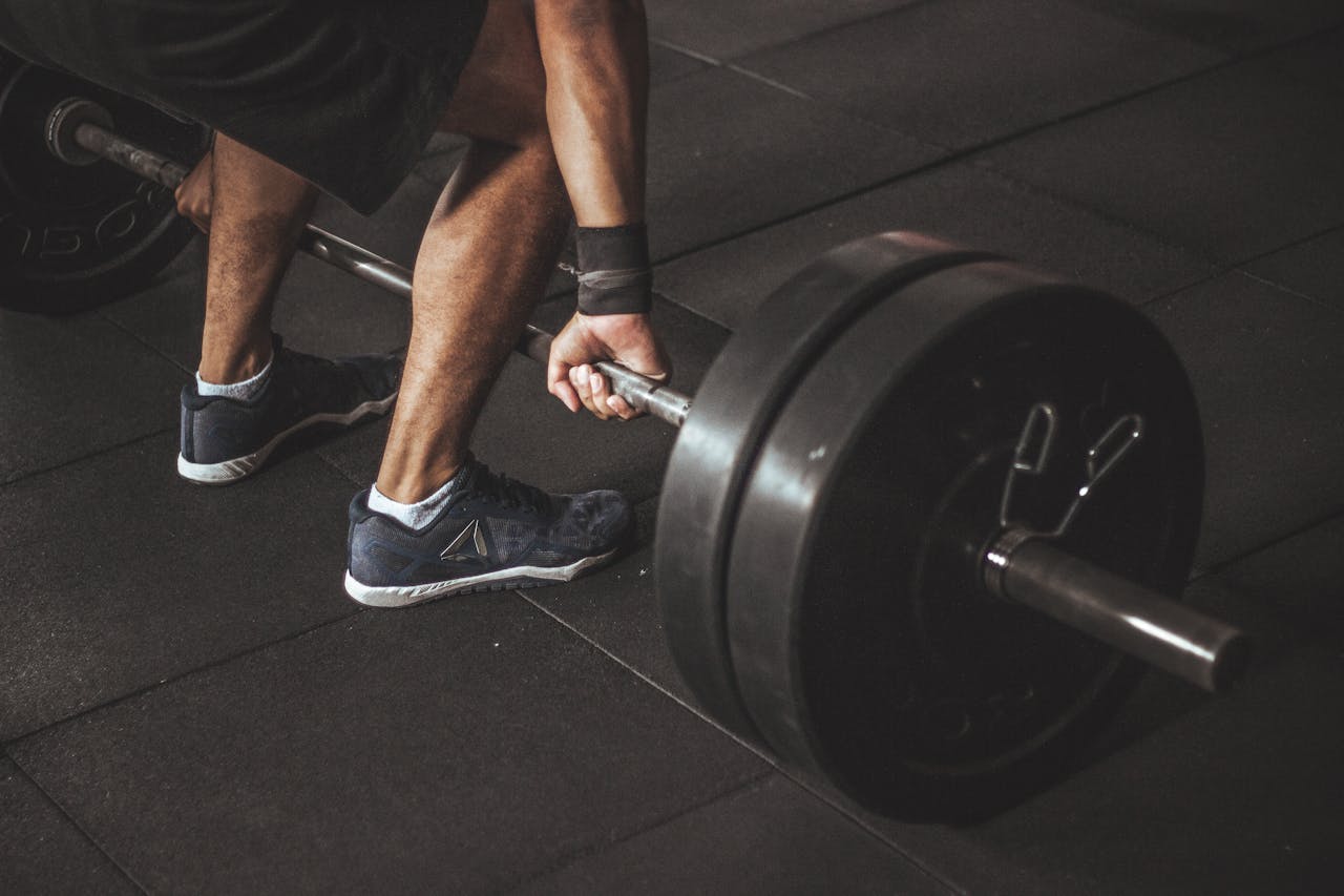 our-services-2 A man lifting a heavy barbell during a gym workout, showcasing strength and fitness.